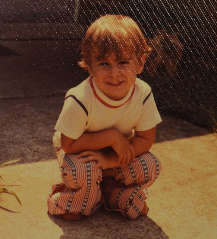 toddler crouching and grinning