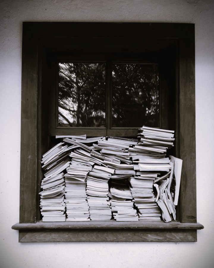 stacks of books crammed into a window