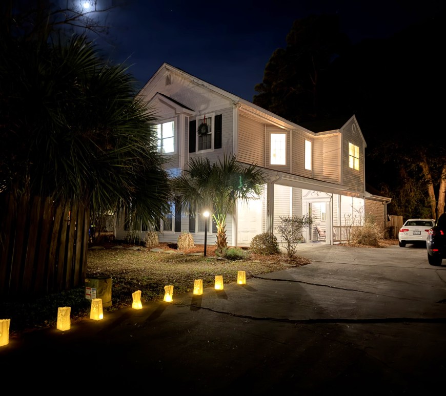 our house and driveway all lit up with luminaria on Christmas Eve, 2025